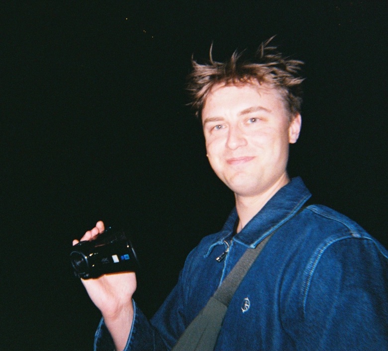 Me at night holding a video camera, with “That’s me” handwritten beside me