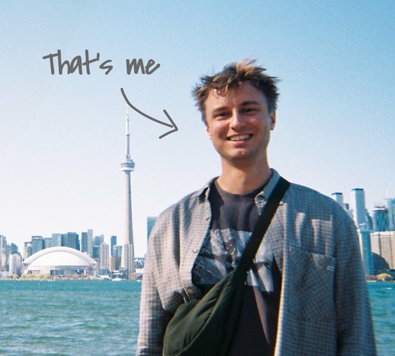 Me, smiling in front of the Toronto skyline, with “That’s me” handwritten beside me
